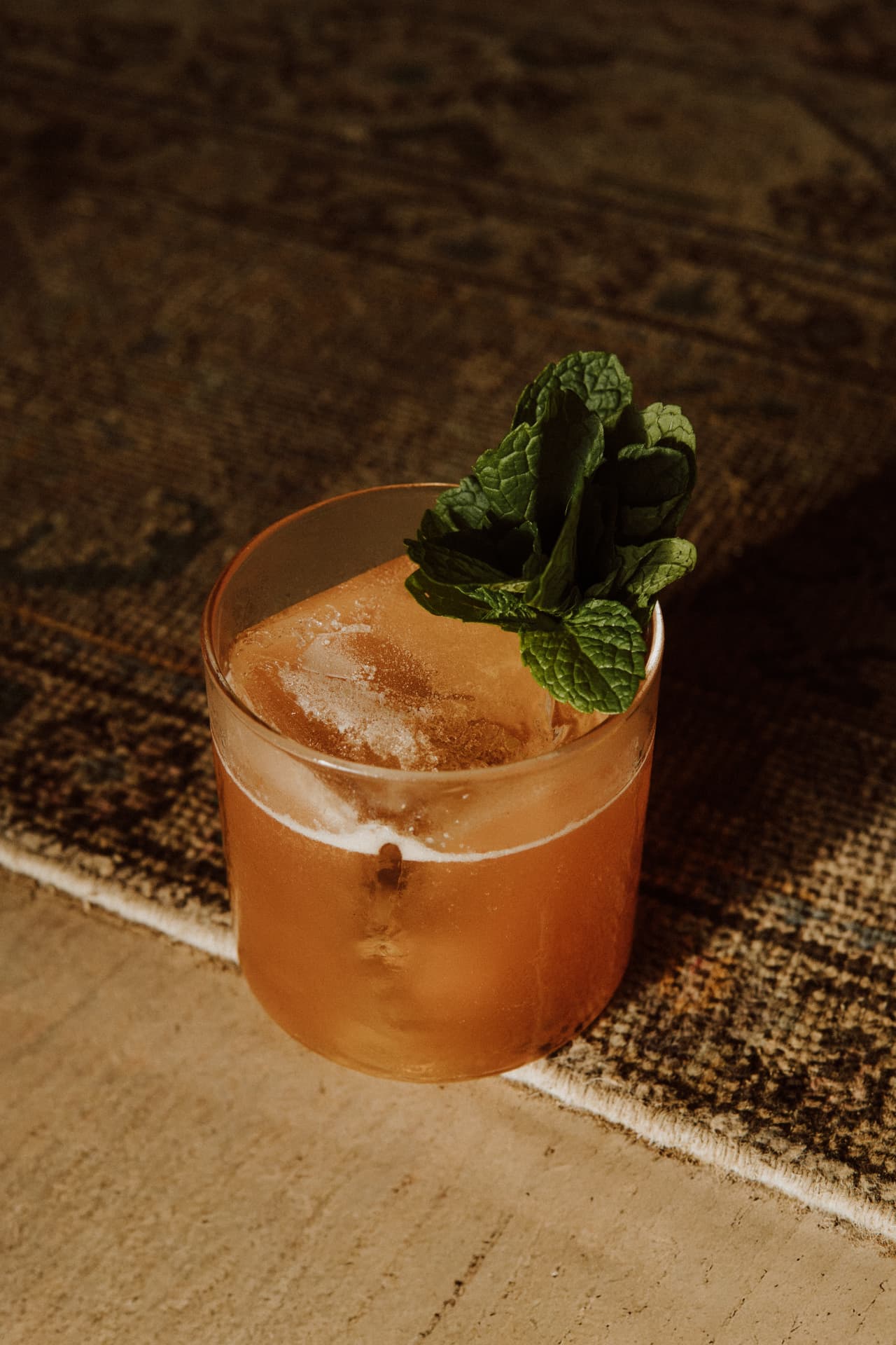 Amber cocktail over ice with fresh mint at TAMAN