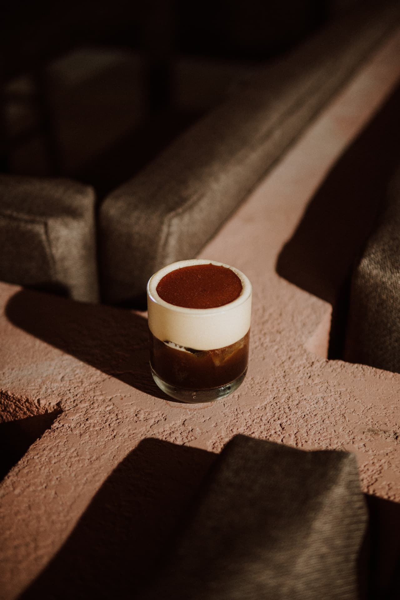 Coffee cocktail with a smooth cream top in warm evening light at TAMAN